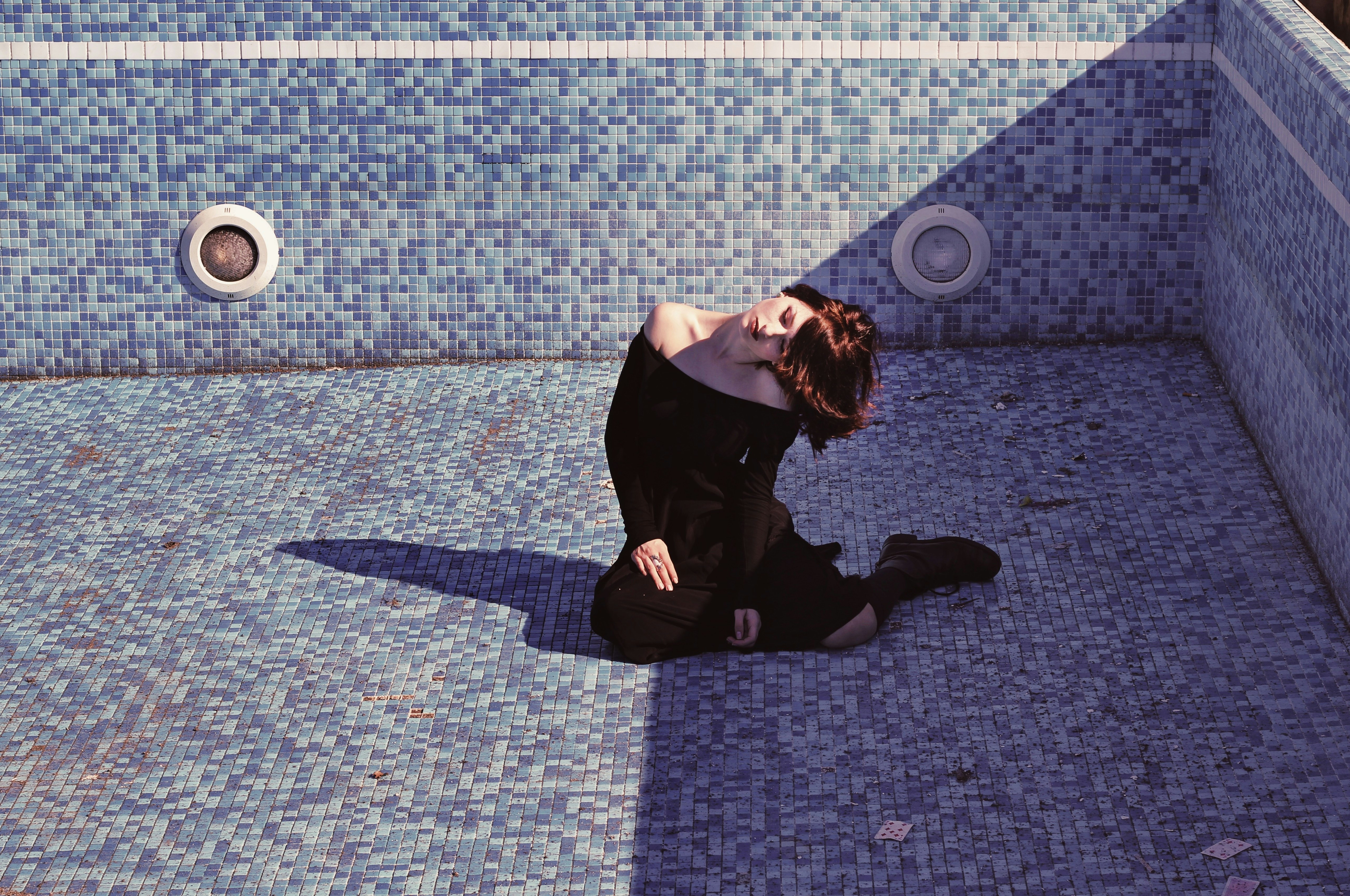 woman sitting inside the empty pool